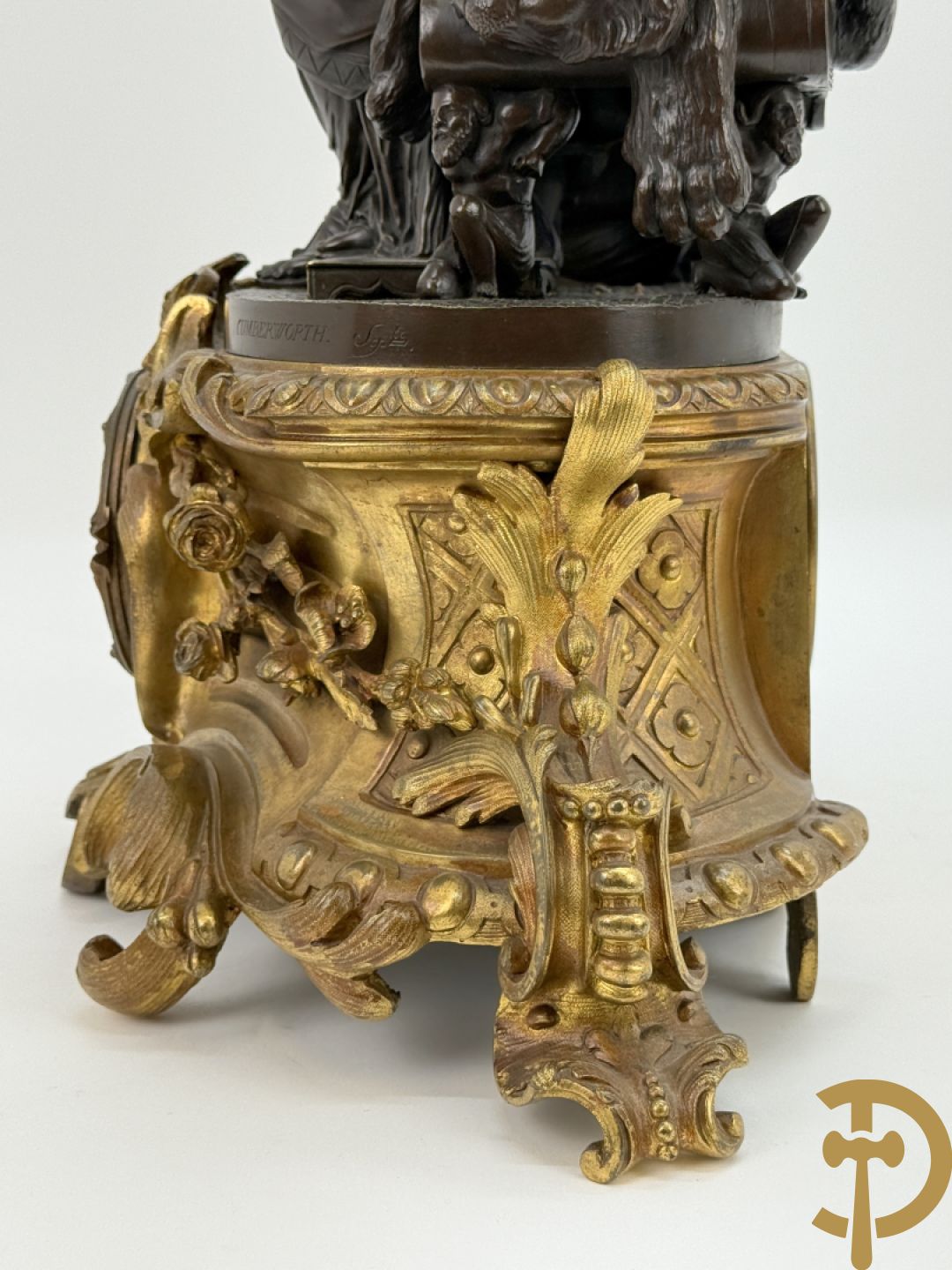 Driedelige bronzen garnituur bestaande uit middenstuk met bronzen vuurvergulde klok, Daubrée gemerkt à Nancy, bovenaan bekroond met Cleopatra met drinkbeker - getekend van Cumberworth sculpteur - geflankeerd door paar cupido