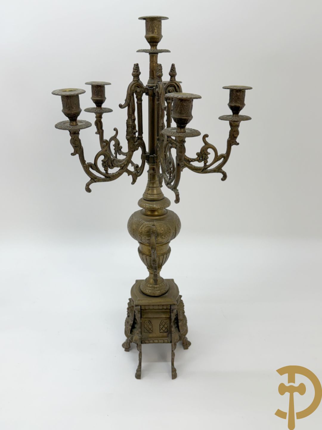 Driedelige koperen garnituur, klok geflankeerd door paar vijfarmige kandelaars