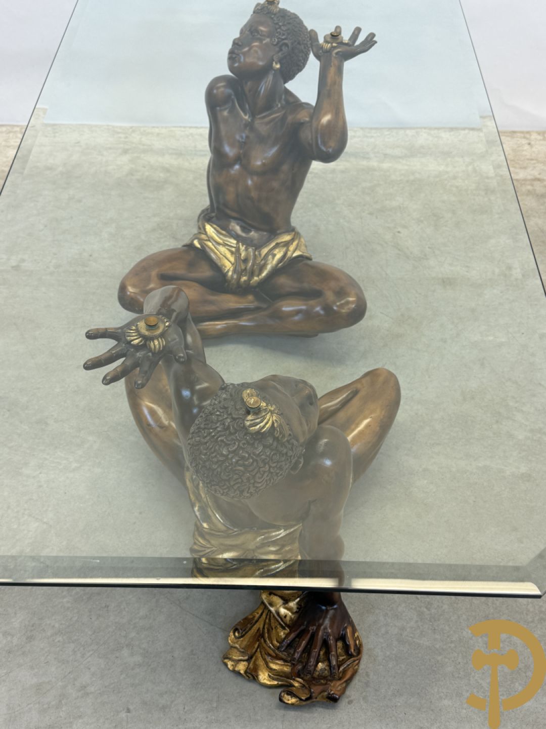 Salontafel met een paar moren met vergulde lendendoek dragende een achthoekig geslepen glazen blad