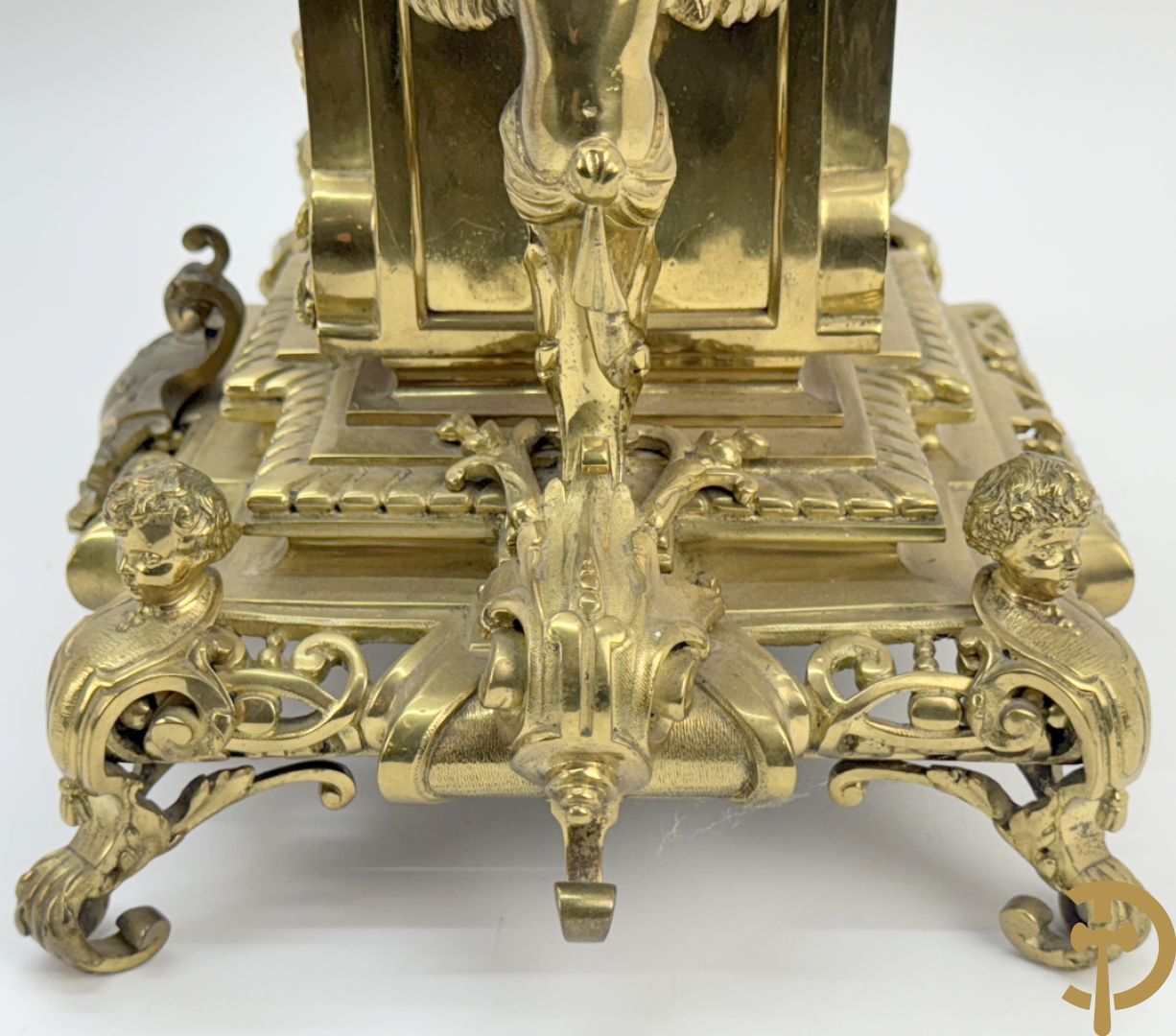 Driedelige bronzen vergulde garntiuur bestaande uit klok met medusahoofden en sfinxen, geflankeerd door paar zevenarmige kandelaars met accanthusranken en sfinxen
