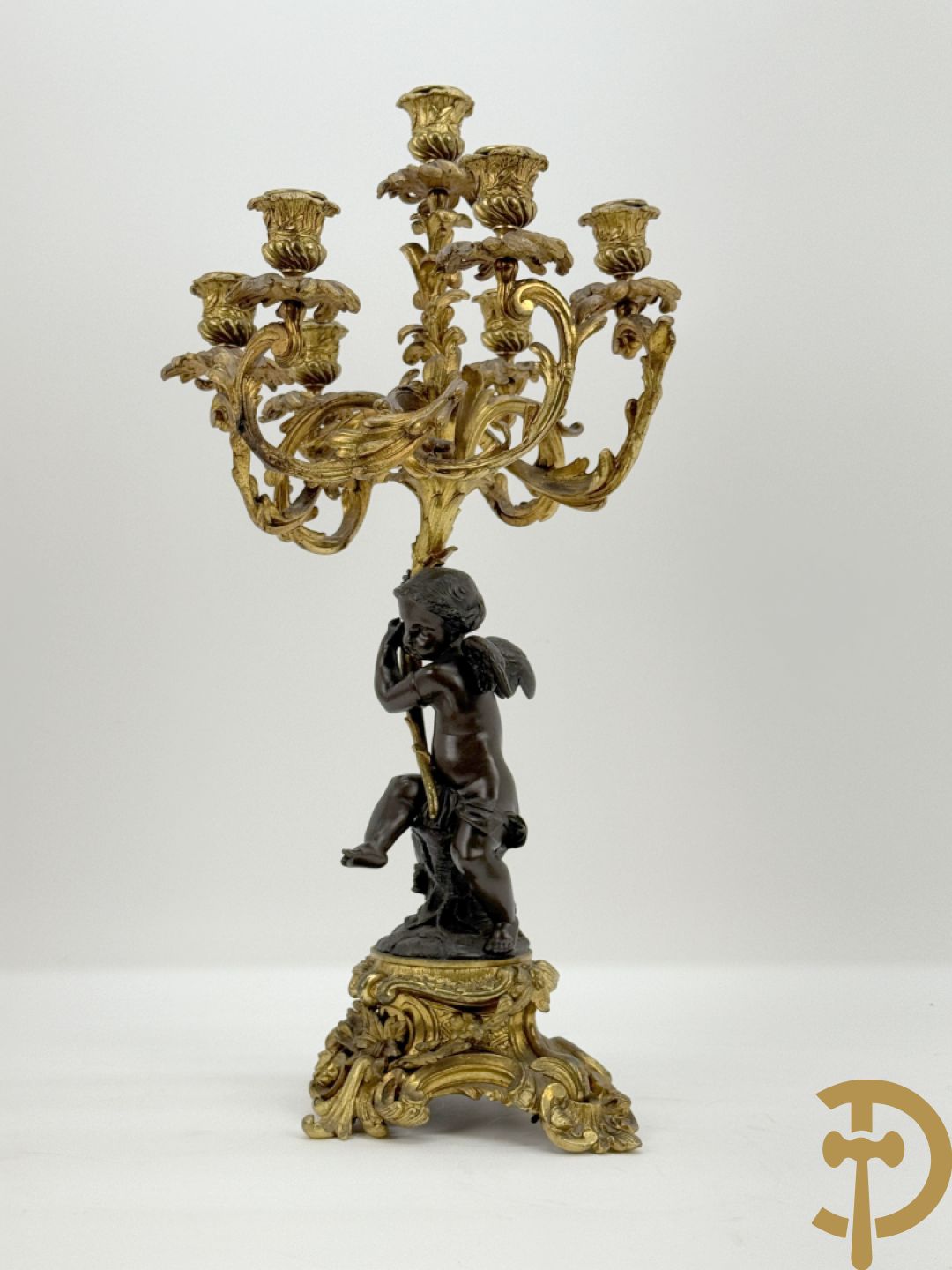 Bronzen cupido dragende een zevenarmige kandelaar