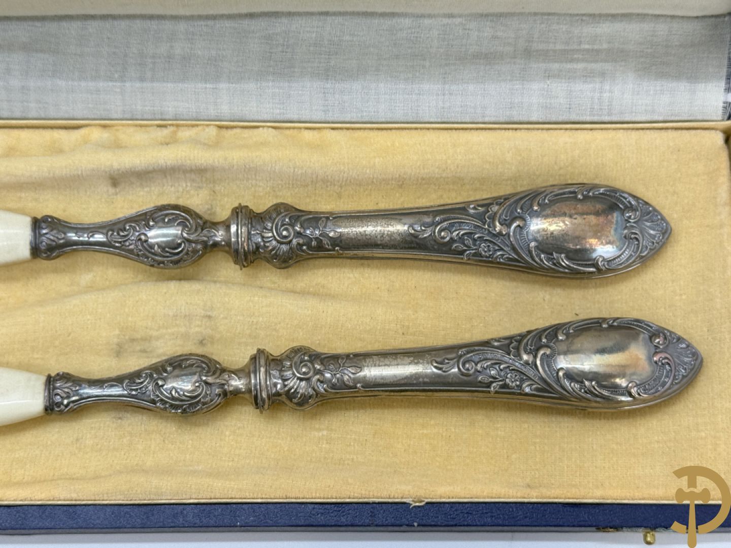 Massief zilveren bestek met Louis XV motieven bestaande uit 12 soeplepels (72 gram per stuk), 12 vorken (78 gram per stuk), 12 messen, 12 dessertvorken (47 gram per stuk), 12 dessertlepels (40 gram per stuk), 12 dessertmessen, 12 koffielepels (22 gram per stuk), slacouvert, taartschep en suikertang