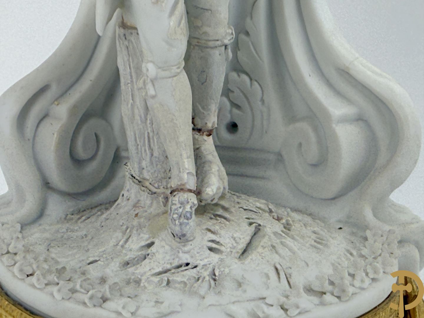 Driedelige porseleinen garnituur met bronsbeslag bestaande uit pendule met dame en amfoor geflankeerd door paar kandelaars bezet met personages