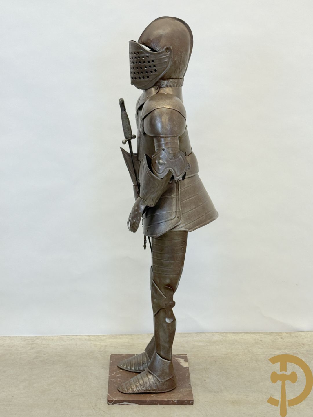 Decoratief plaatstalen ridderharnas met zwaard op marmeren voet