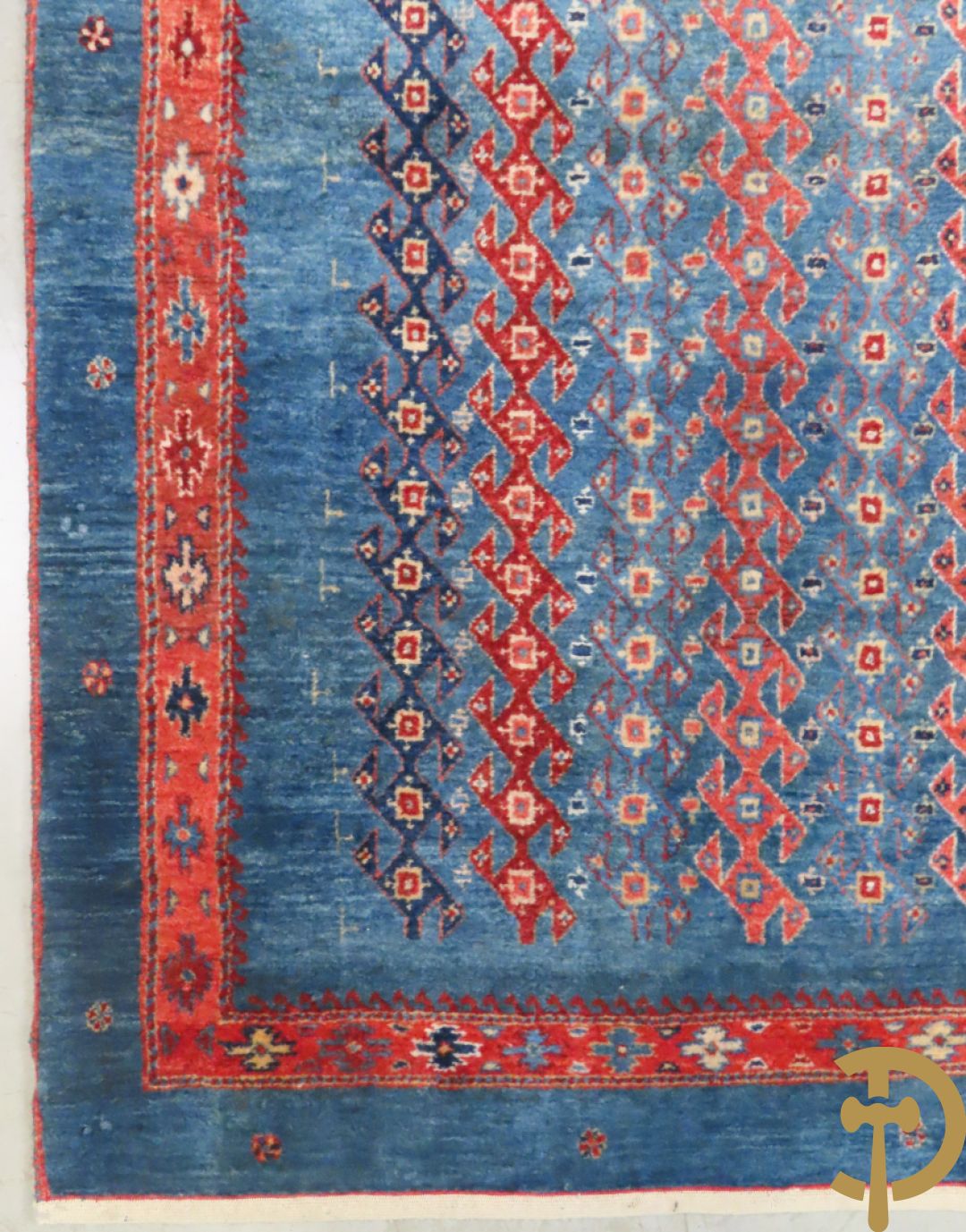 Oosters handgeknoopt tapijt met geometrische patronen op blauwe fond