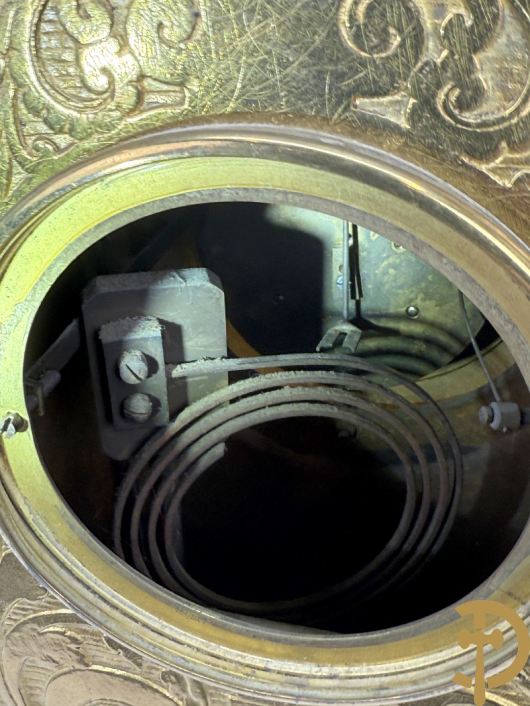 Vuurvergulde bronzen pendule, zijdelings bezet met gevleugelde dames, bovenaan met amfoor