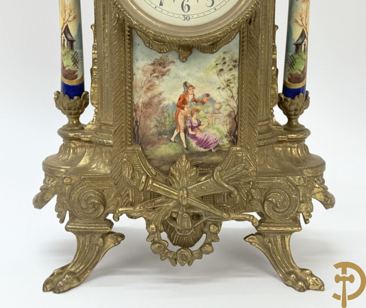 Driedelige koperen garnituur bestaande uit pendule met beschilderd romantisch tafereel en amfoor, zijdelings bezet met paar cassolettes met geanimeerde scènes, onleesbaar getekend rechts onder klok