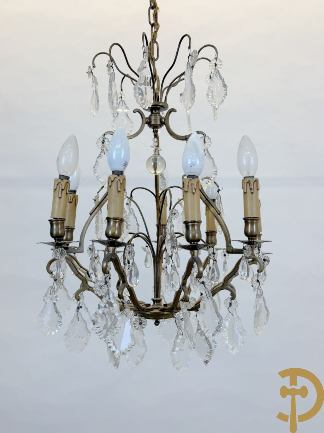 Franse koperen luchter met 8 lichtpunten en kristallen bellen op koperen chassis