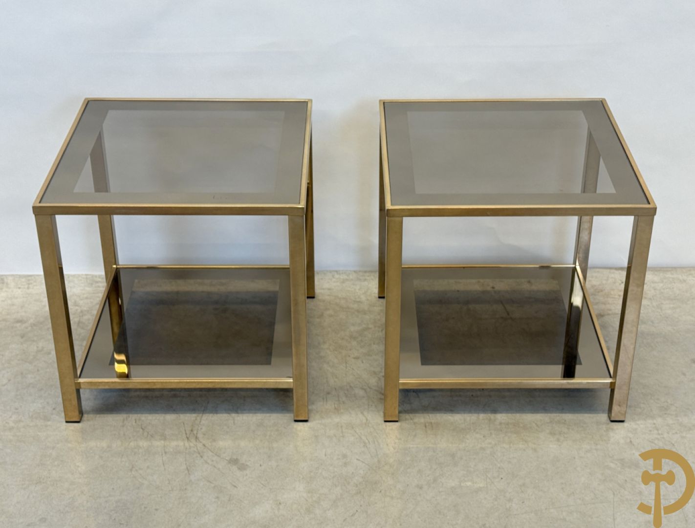 Paar koperen bout de canapé bijzettafels met afgeboord fumé/spiegelglas