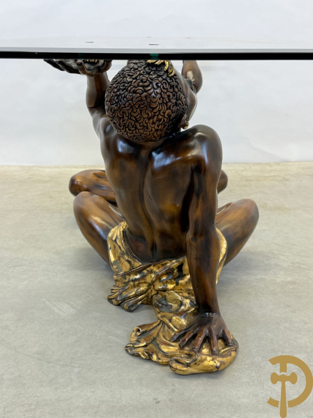 Salontafel met een paar moren met vergulde lendendoek dragende een achthoekig geslepen glazen blad