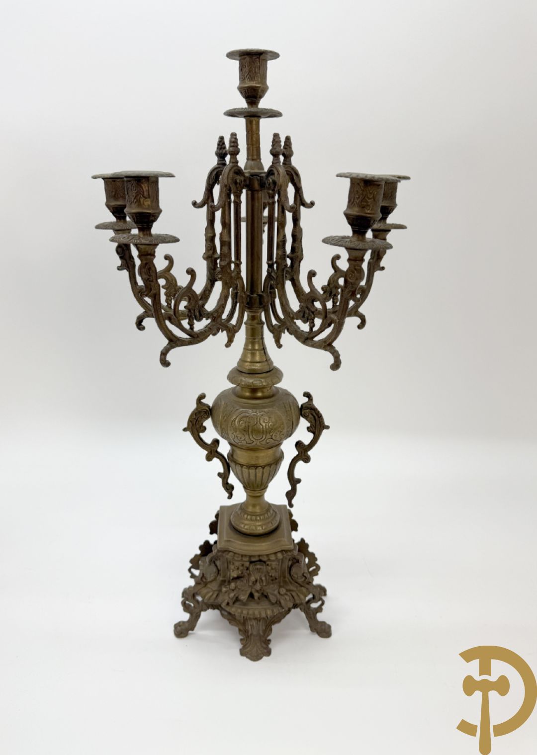 Driedelige koperen garnituur, klok geflankeerd door paar vijfarmige kandelaars