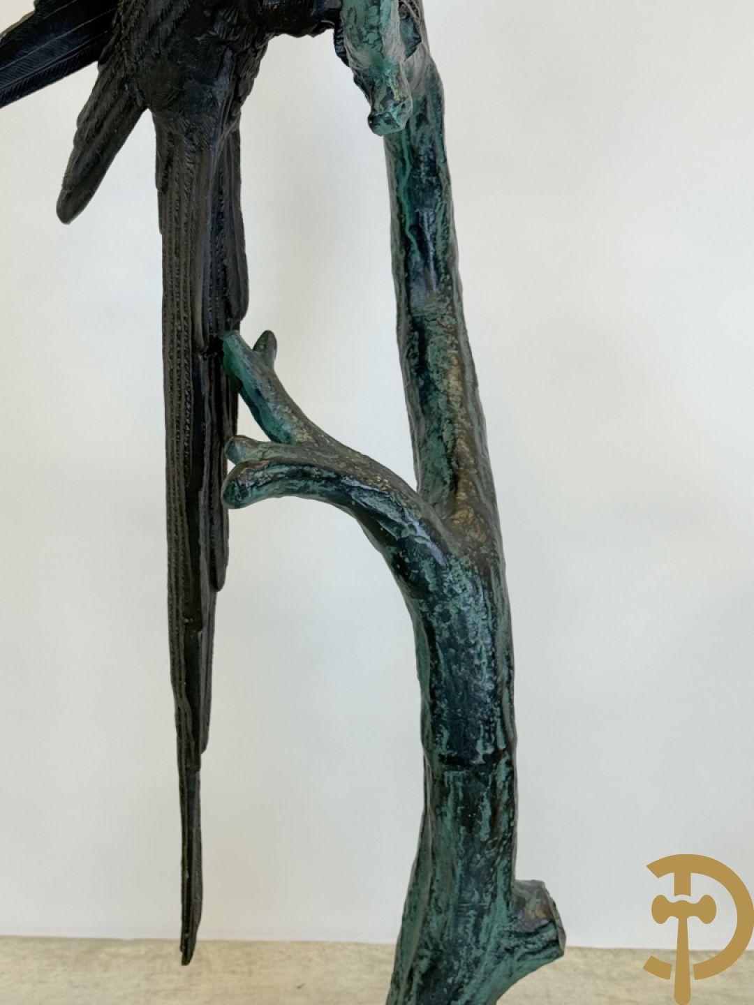 Metalen gepatineerde papegaai op boomstronk