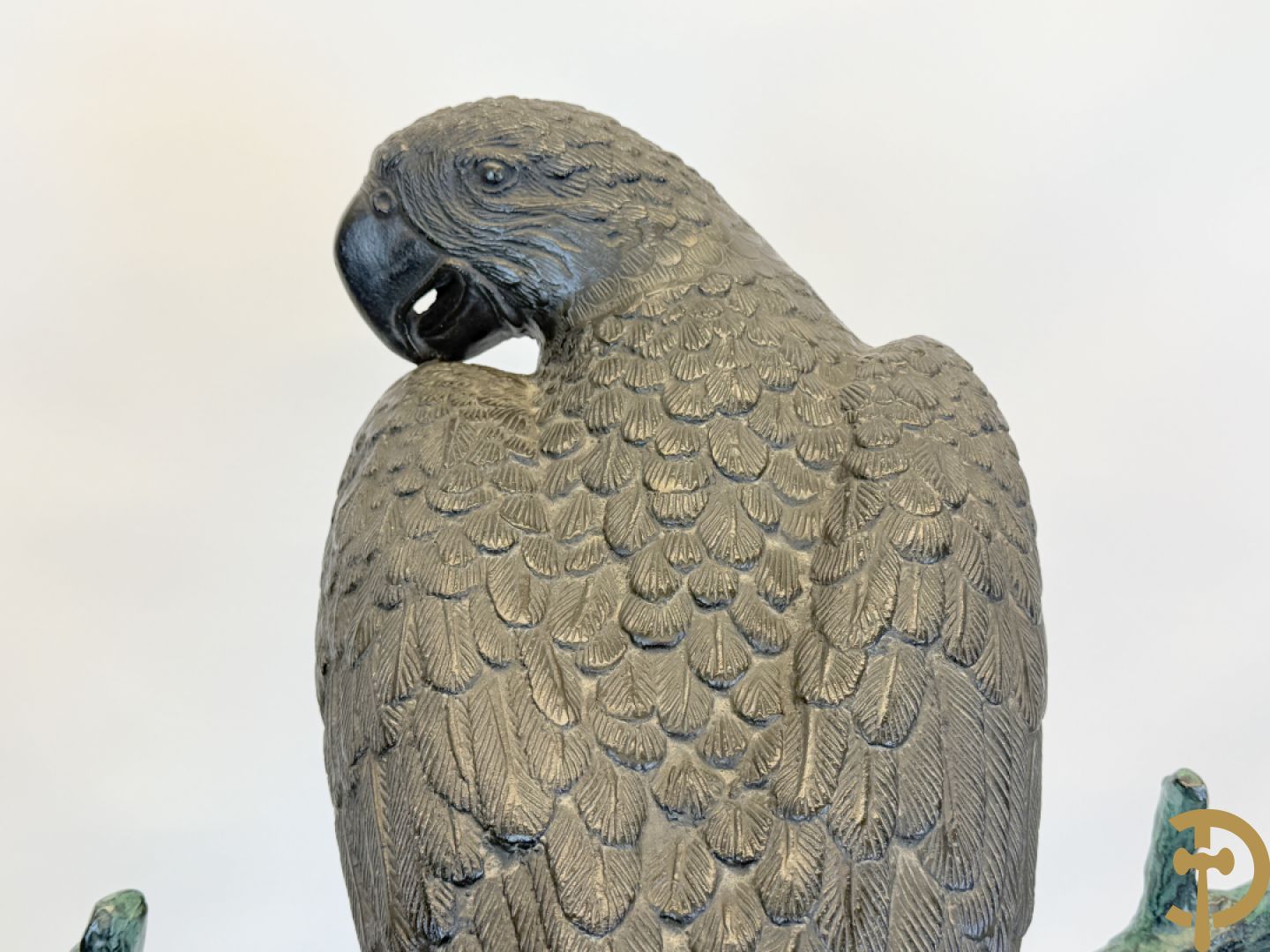 Metalen gepatineerde papegaai op boomstronk