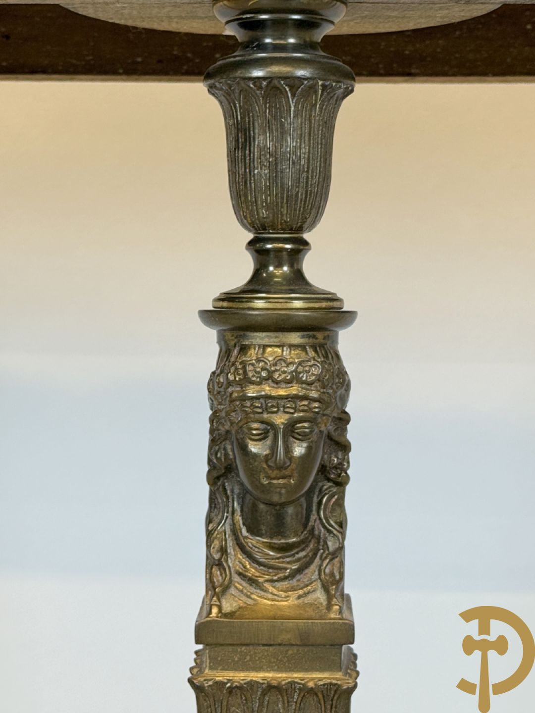 Console op bronzen poten met dameshoofden bezet, bovenaan met groen marmeren blad