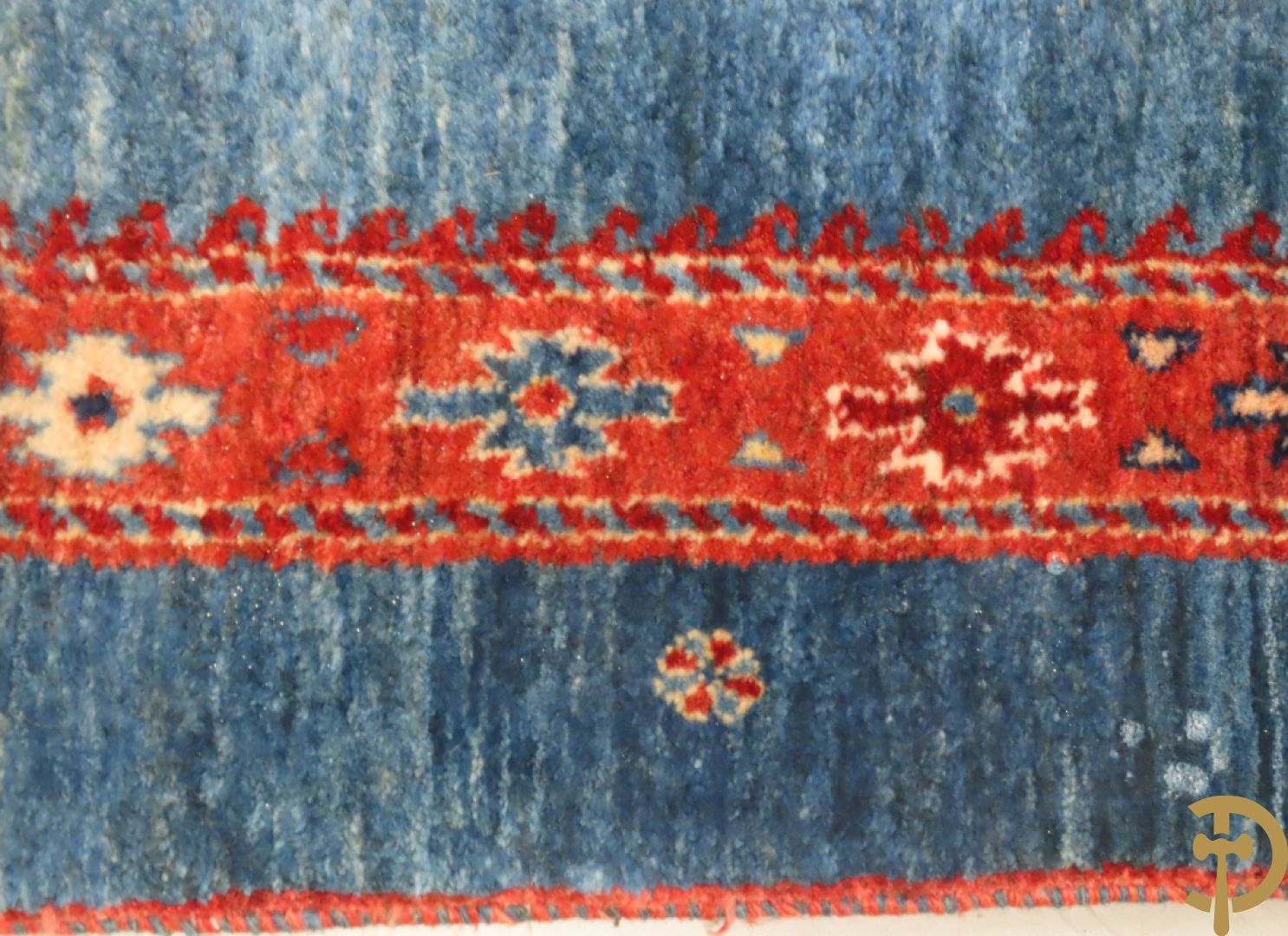 Oosters handgeknoopt tapijt met geometrische patronen op blauwe fond