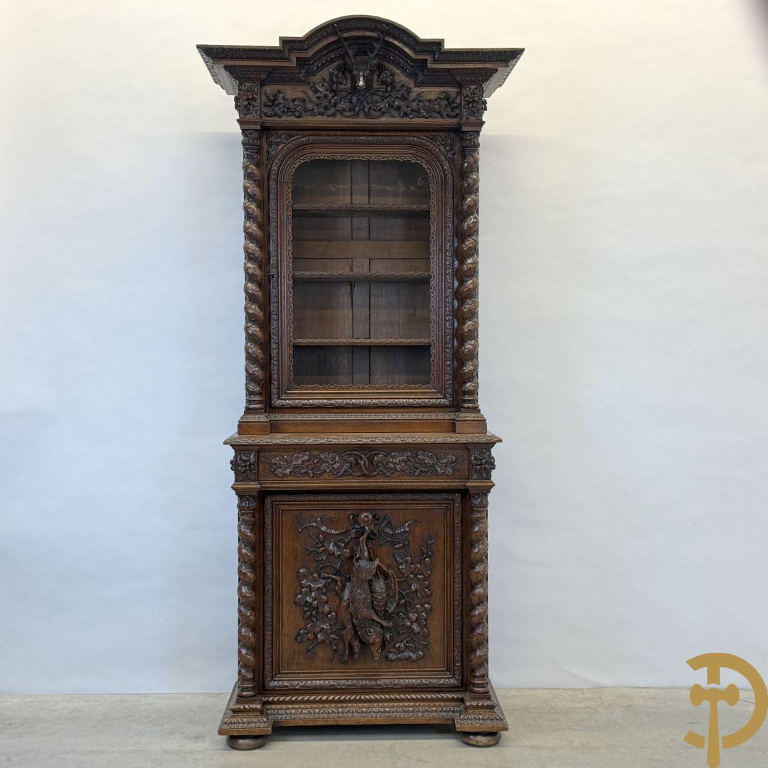 Massief eiken jacht deux-corps, bovenaan met vitrine, zijdelings met getorste zuilen, onderaan met sculptuur van everzwijn en eikebladranken