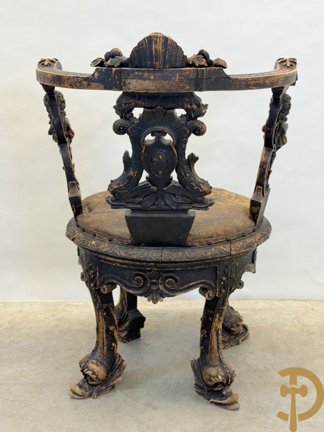 Gesculpteerde draaibare gondelvormige stoel steunend op 4 poten in de vorm van dolfijnen, bovenaan met kariathiden en engelenkoppen