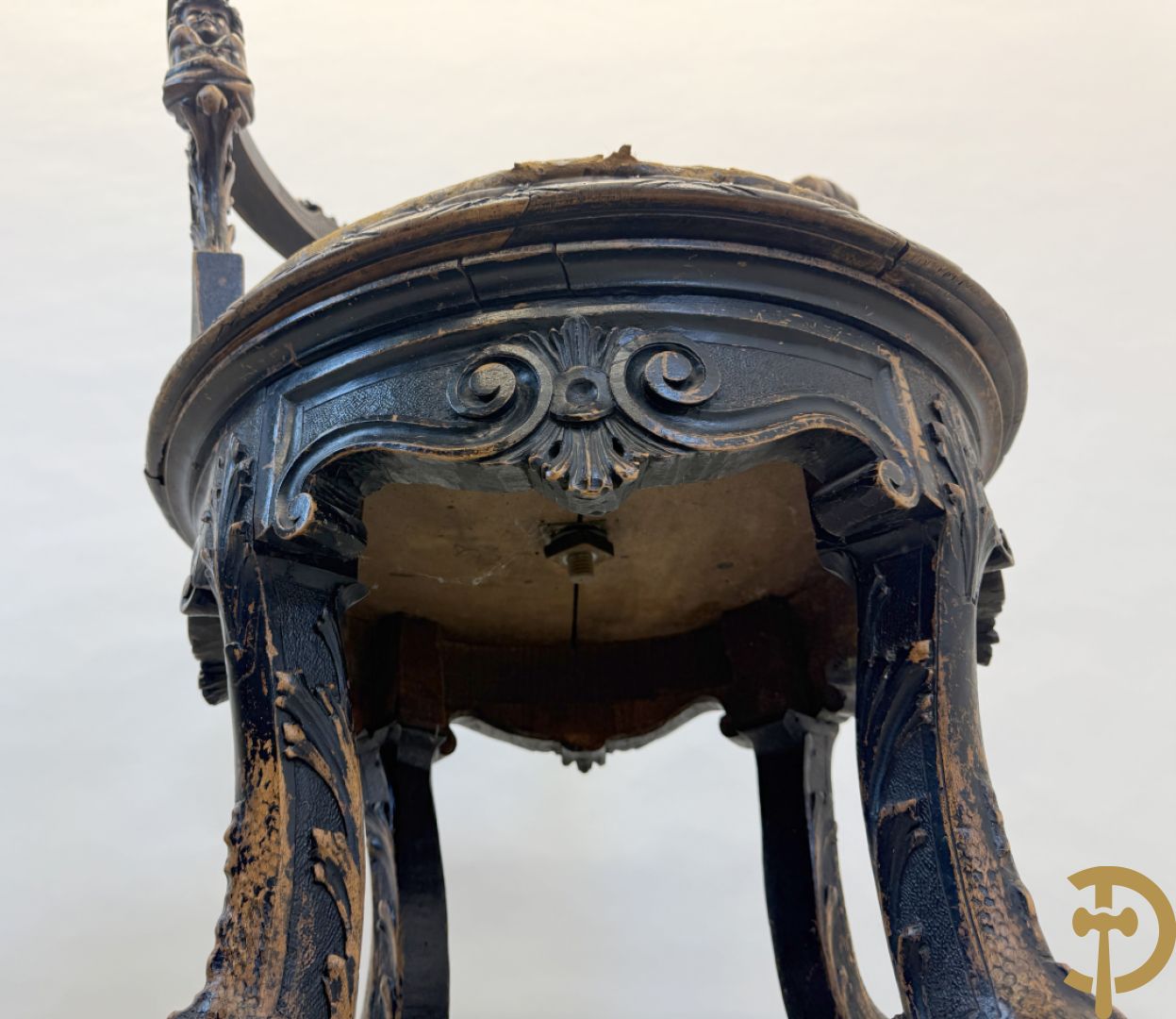 Gesculpteerde draaibare gondelvormige stoel steunend op 4 poten in de vorm van dolfijnen, bovenaan met kariathiden en engelenkoppen