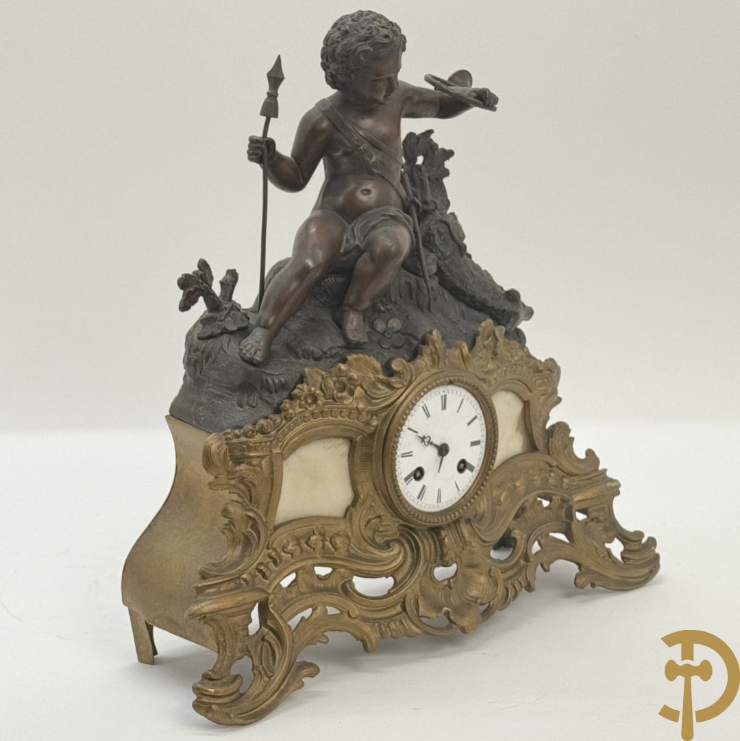 Zamak pendule met accanthusranken en bekroond met cupido met jachthoorn