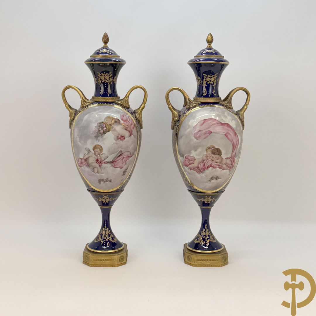 Paar Sèvres stijl vazen met bronzen oren en éénzijdig decor van cupido's in de wolken, getekend van Jeanne - achterkant met vergulde ornamenten, gemerkt Sèvres op de voet