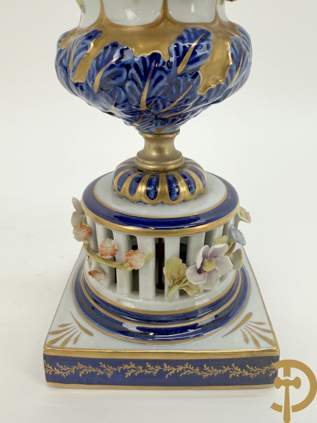 Porseleinen siervaas met handbeschilderd geanimeerd decor bezet met basrelief van bloemen en bovenaan bekroond met deksel met vogel