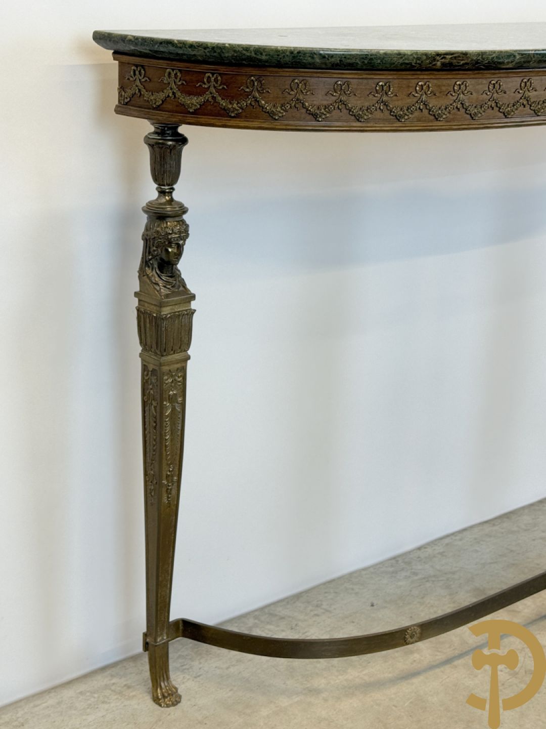Console op bronzen poten met dameshoofden bezet, bovenaan met groen marmeren blad