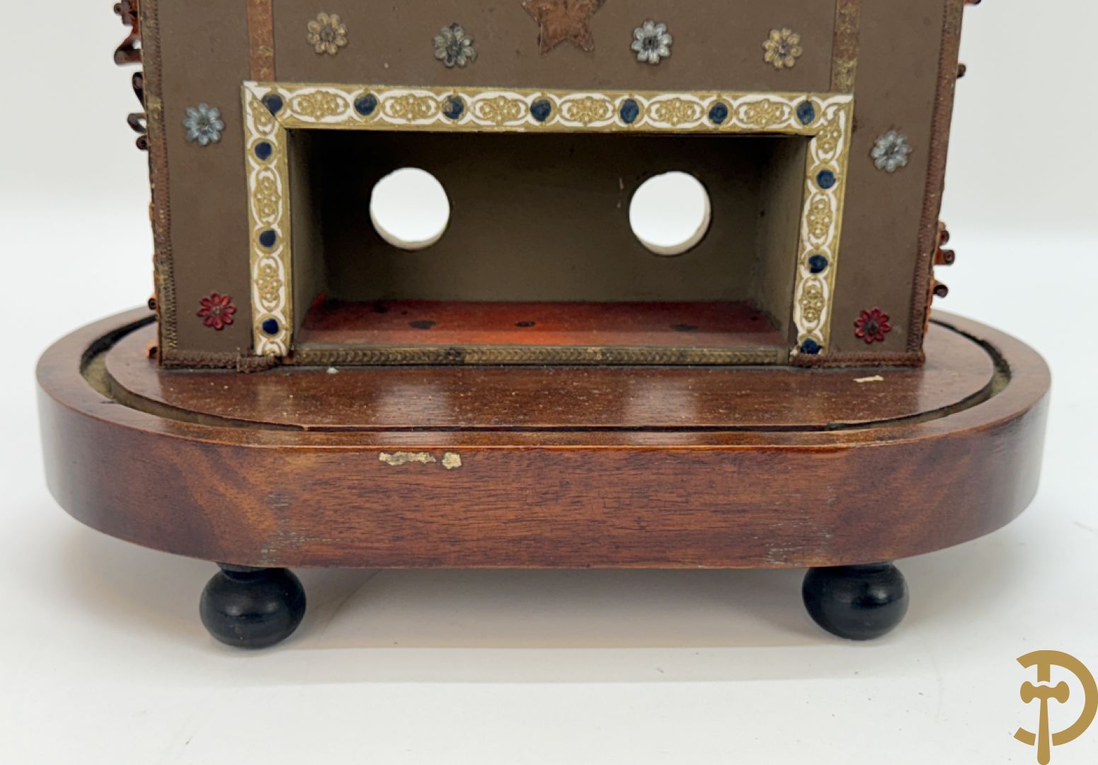 Relikwiehouder in de vorm van een altaar met Christusnagel en omgeven door papperollen - onder stolp