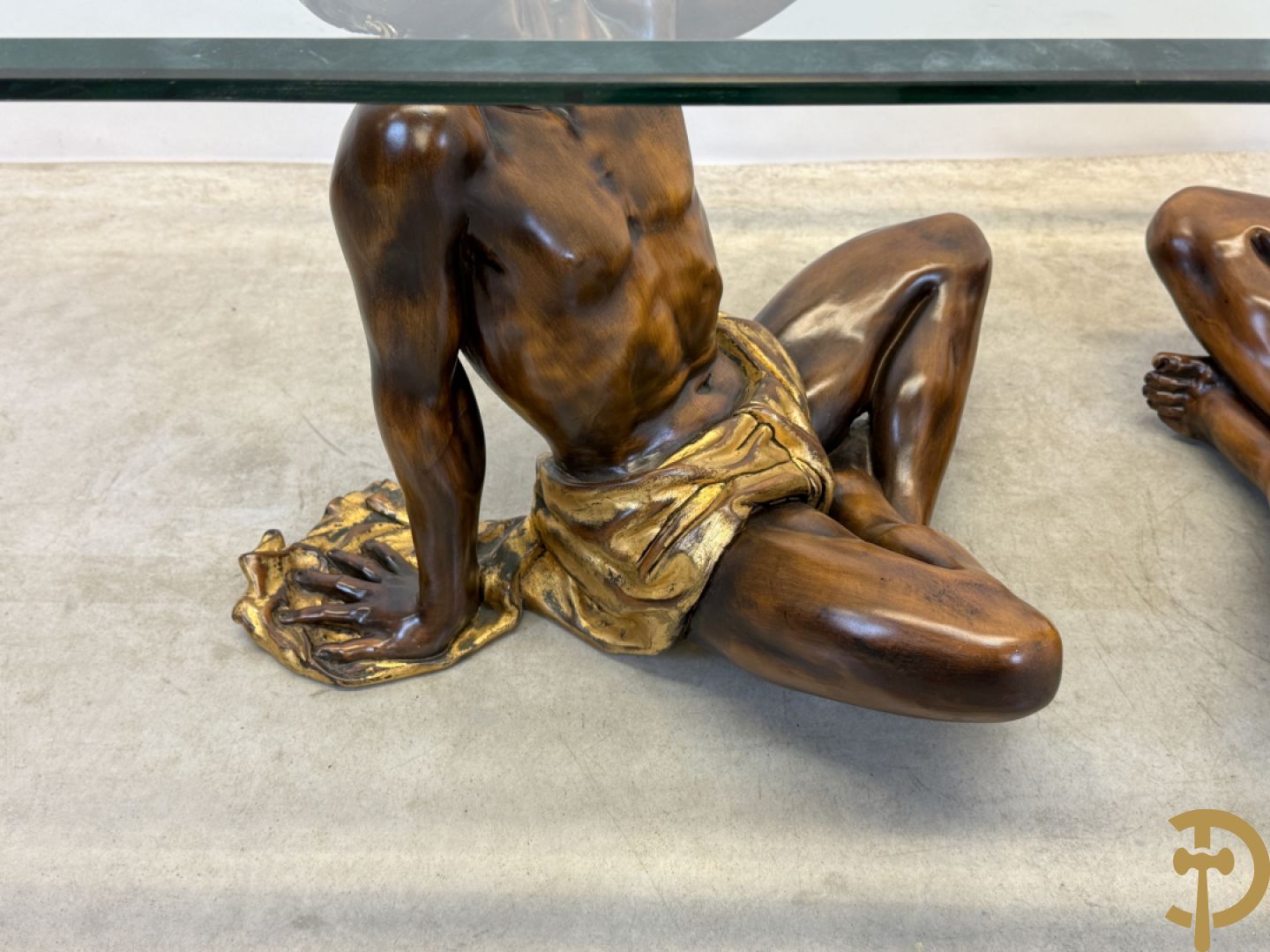 Salontafel met een paar moren met vergulde lendendoek dragende een achthoekig geslepen glazen blad