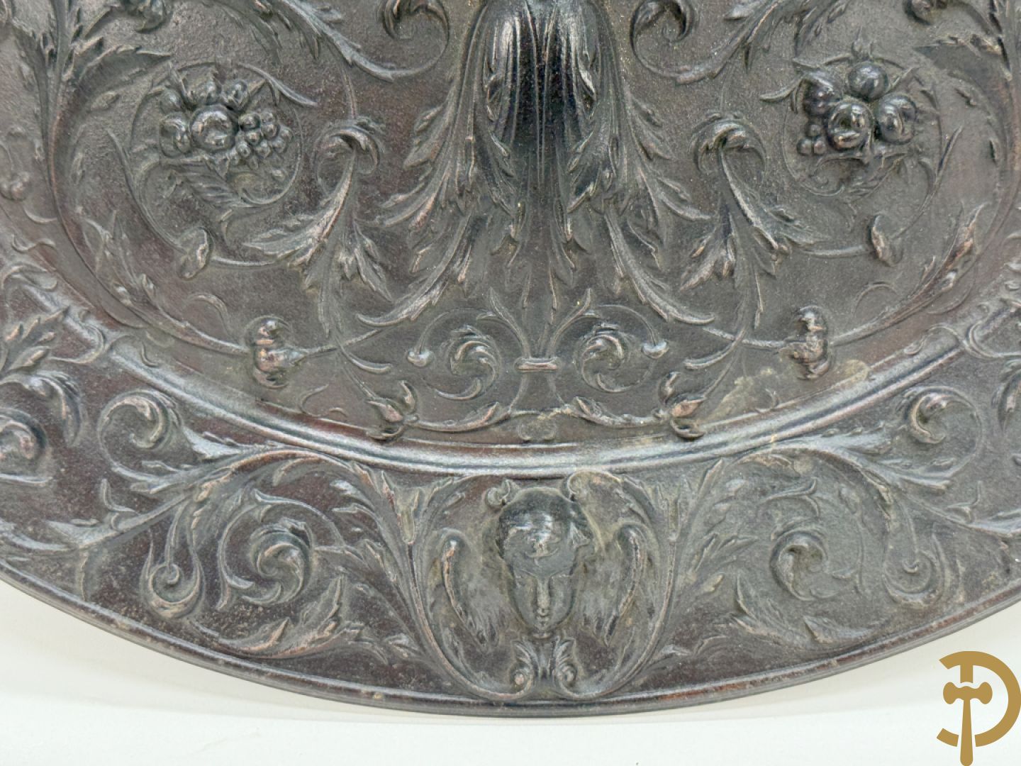 Metalen ovale schotel met dame omgeven door bloemen en accanthusranken, achteraan getekend American Radiator Cie