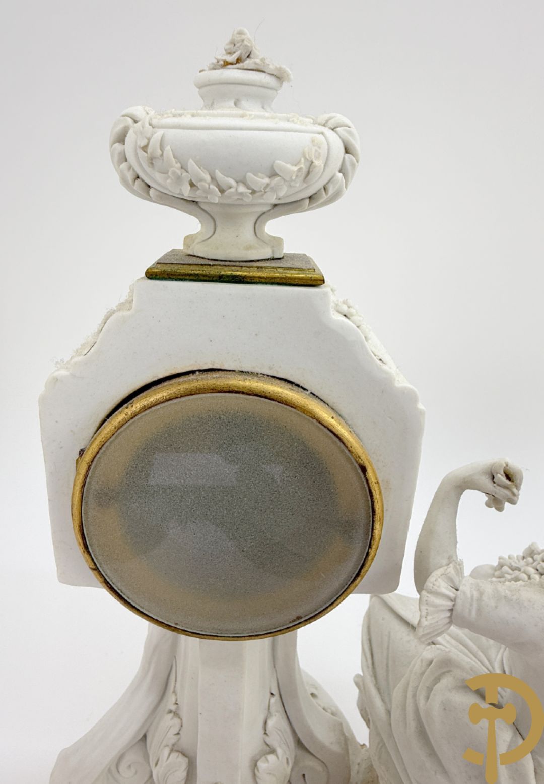 Driedelige porseleinen garnituur met bronsbeslag bestaande uit pendule met dame en amfoor geflankeerd door paar kandelaars bezet met personages