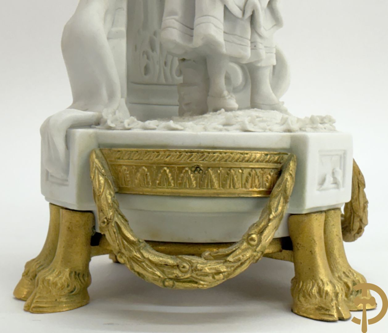 Driedelige porseleinen garnituur met bronsbeslag bestaande uit pendule met dame en amfoor geflankeerd door paar kandelaars bezet met personages