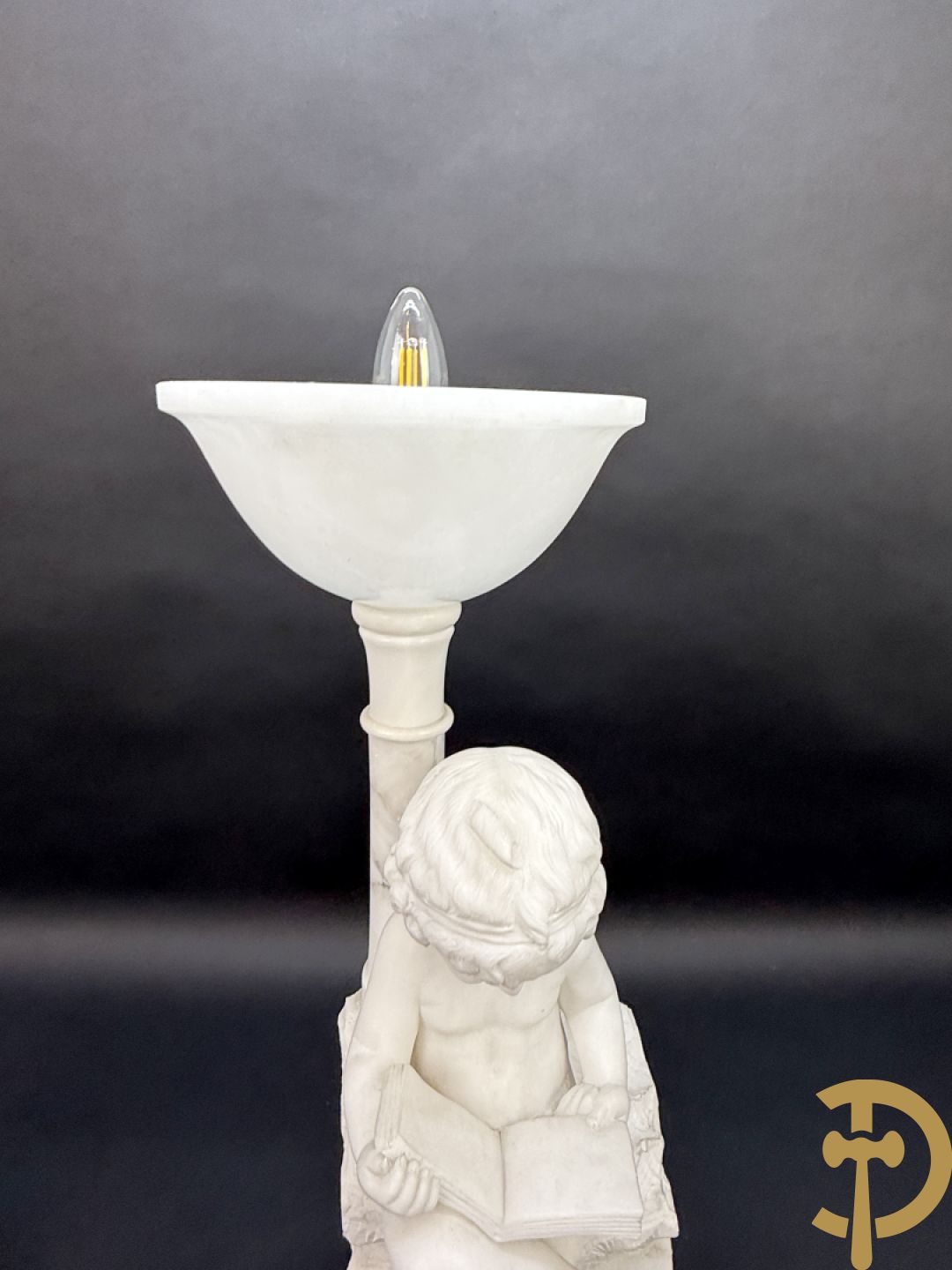 Albast beeld van jongen met boek en lamp