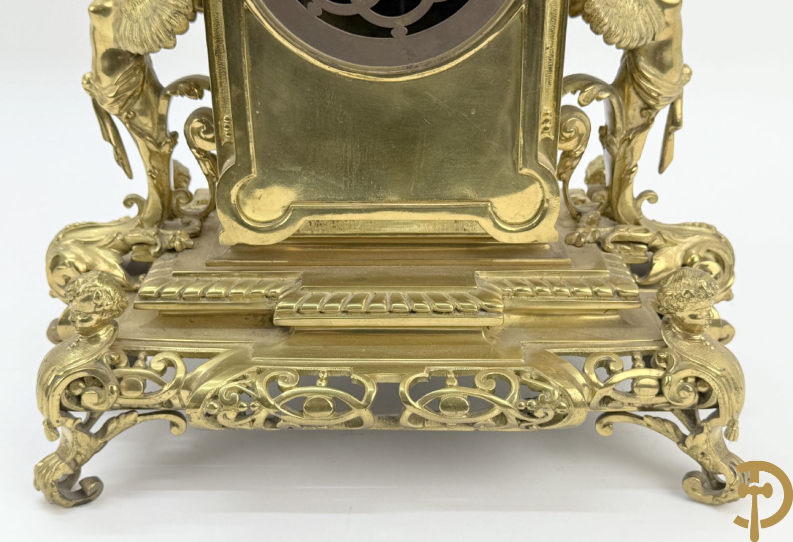 Driedelige bronzen vergulde garntiuur bestaande uit klok met medusahoofden en sfinxen, geflankeerd door paar zevenarmige kandelaars met accanthusranken en sfinxen