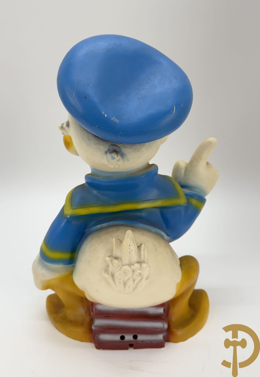 Plastic Donald Duck zittend op 3 boeken, onderaan gemerkt Disney + houten gesculpteerd beschilderde eend