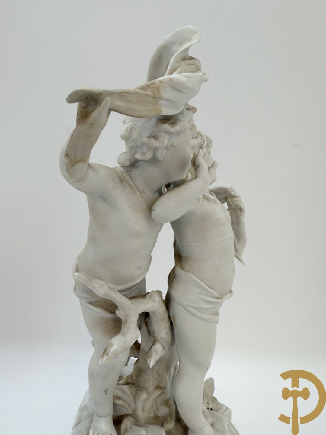 Driedelige porseleinen garnituur bestaande uit pendule bezet met lieftallig koppel, geflankeerd door paar kandelaars met cupido