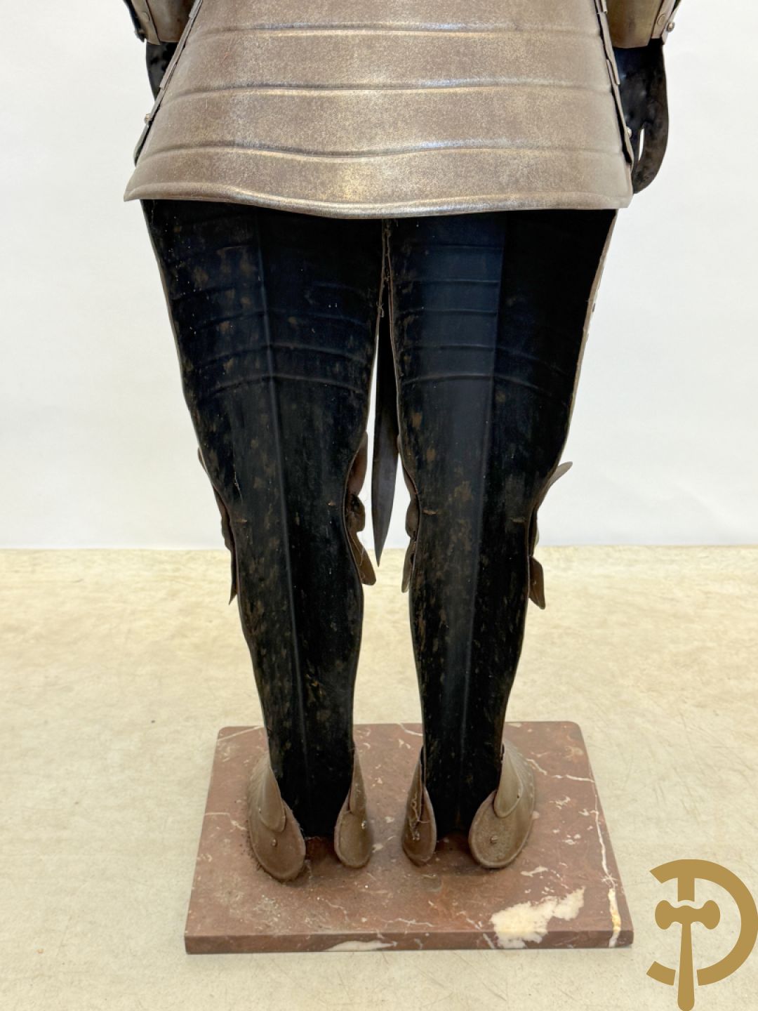 Decoratief plaatstalen ridderharnas met zwaard op marmeren voet