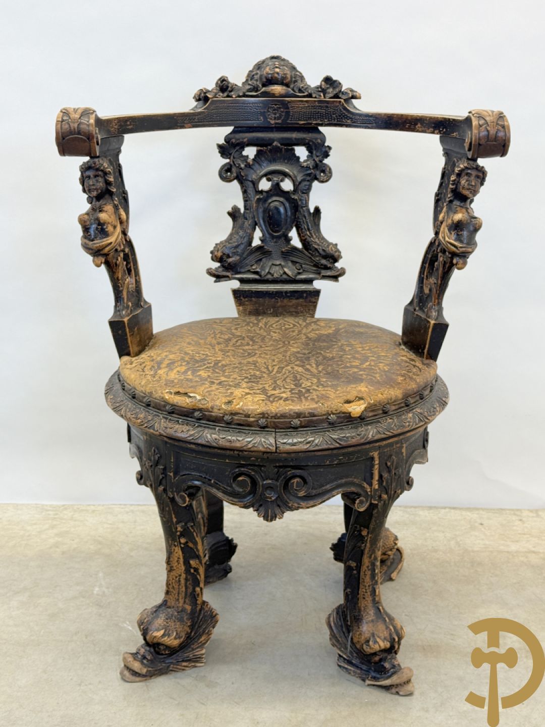 Gesculpteerde draaibare gondelvormige stoel steunend op 4 poten in de vorm van dolfijnen, bovenaan met kariathiden en engelenkoppen