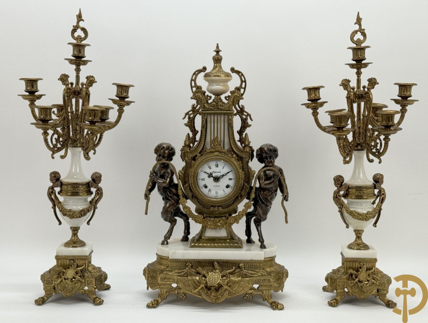 Driedelige koperen garnituur, centraal met harp geflankeerd door paar cupido