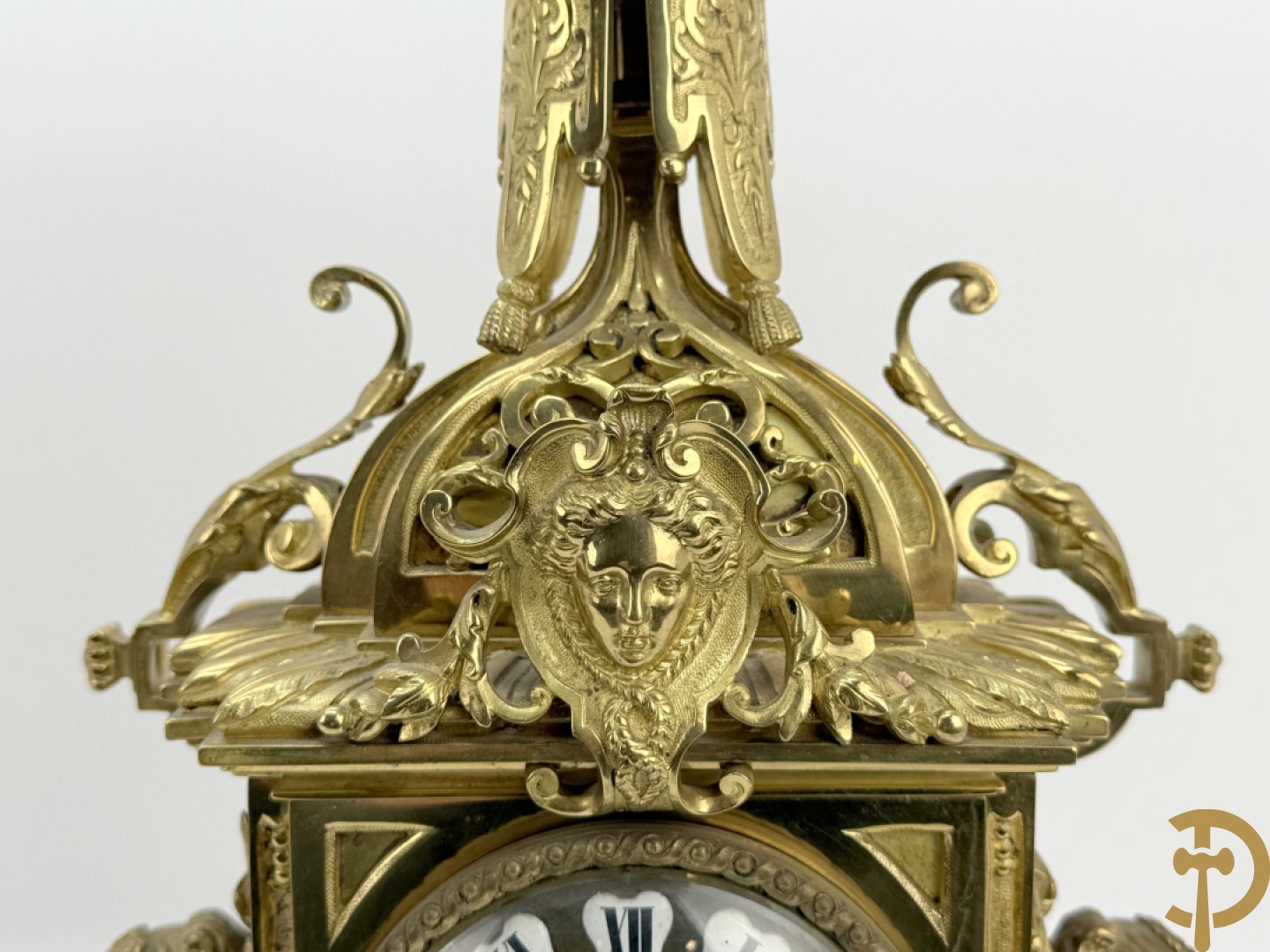 Driedelige bronzen vergulde garntiuur bestaande uit klok met medusahoofden en sfinxen, geflankeerd door paar zevenarmige kandelaars met accanthusranken en sfinxen