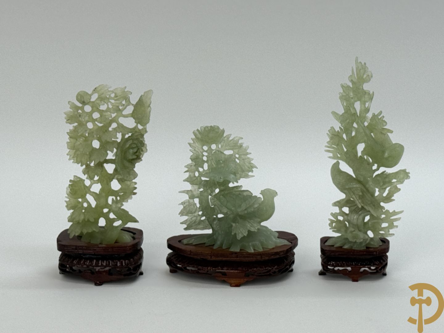 Drie jade sculpturen van vogels met bloemen op sokkel