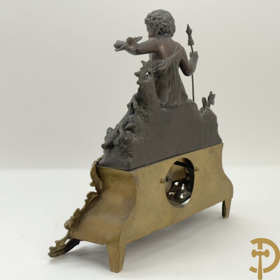 Zamak pendule met accanthusranken en bekroond met cupido met jachthoorn