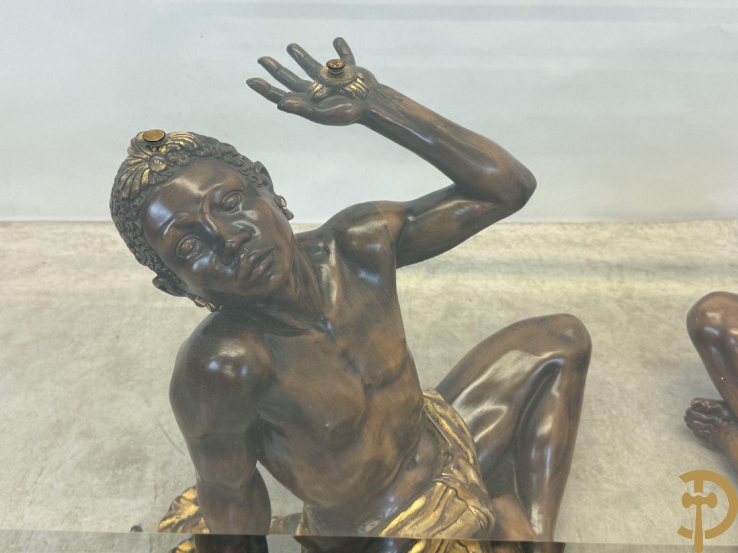 Salontafel met een paar moren met vergulde lendendoek dragende een achthoekig geslepen glazen blad