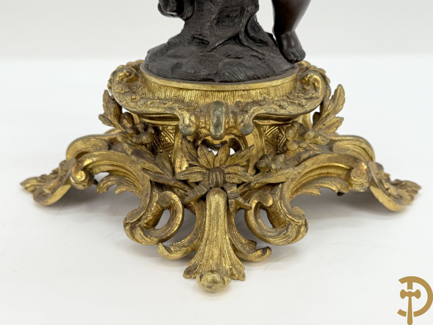 Bronzen cupido dragende een zevenarmige kandelaar