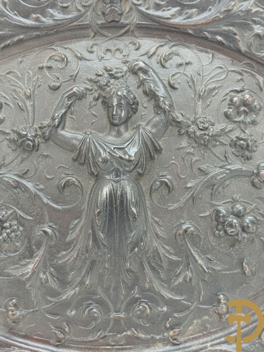 Metalen ovale schotel met dame omgeven door bloemen en accanthusranken, achteraan getekend American Radiator Cie