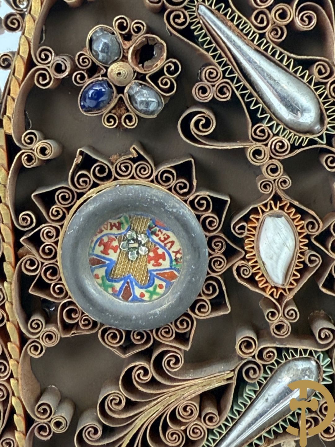 Relikwiehouder in de vorm van een altaar met Christusnagel en omgeven door papperollen - onder stolp