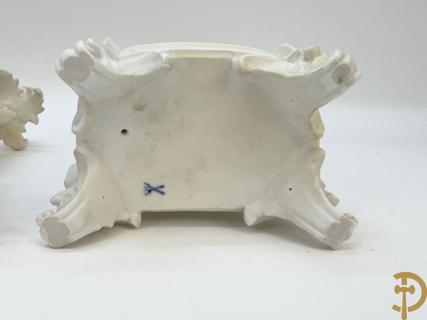 Driedelige porseleinen garnituur bestaande uit pendule bezet met lieftallig koppel, geflankeerd door paar kandelaars met cupido