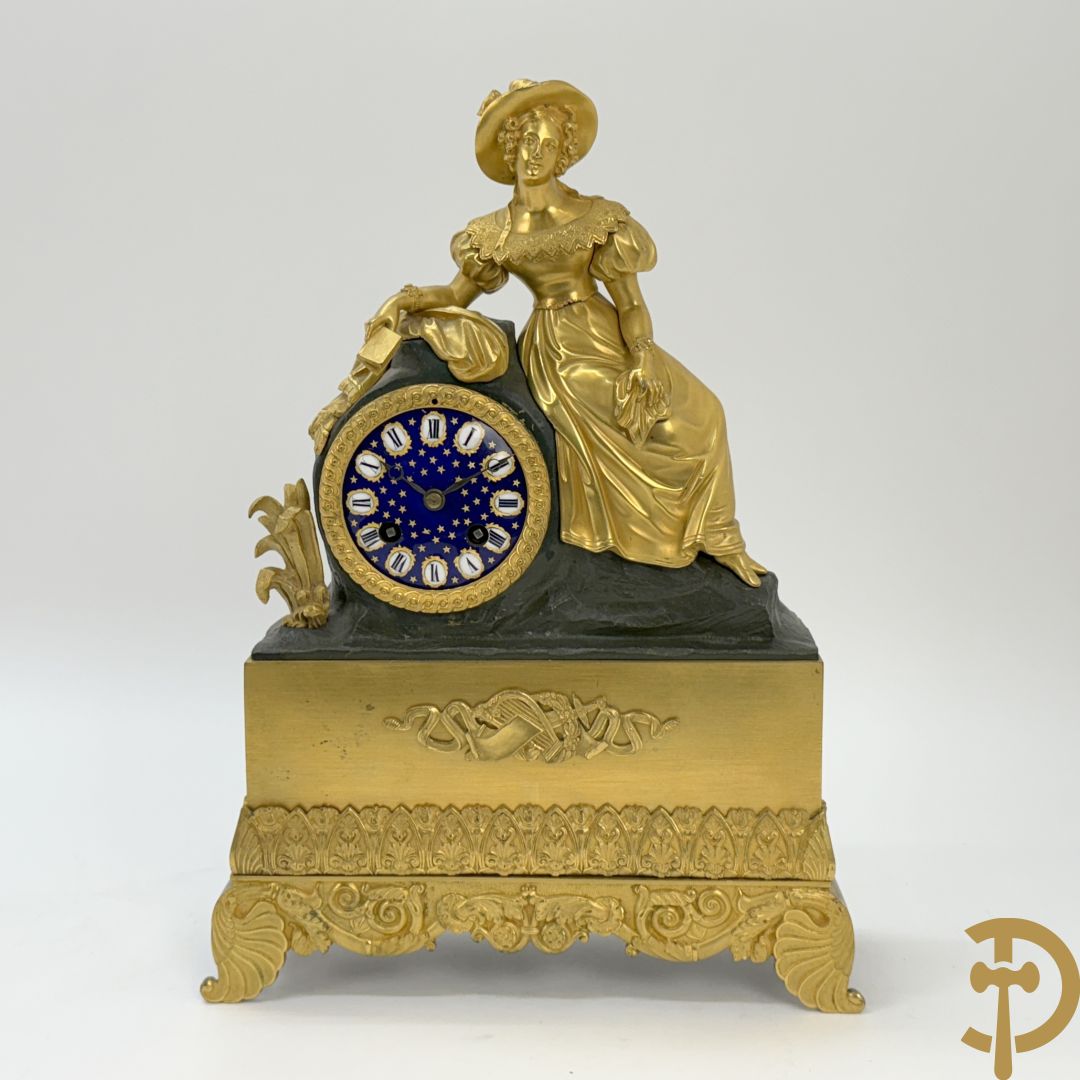 Vergulde pendule met liggende dame en wijzerplaat in blauw email, Charles X