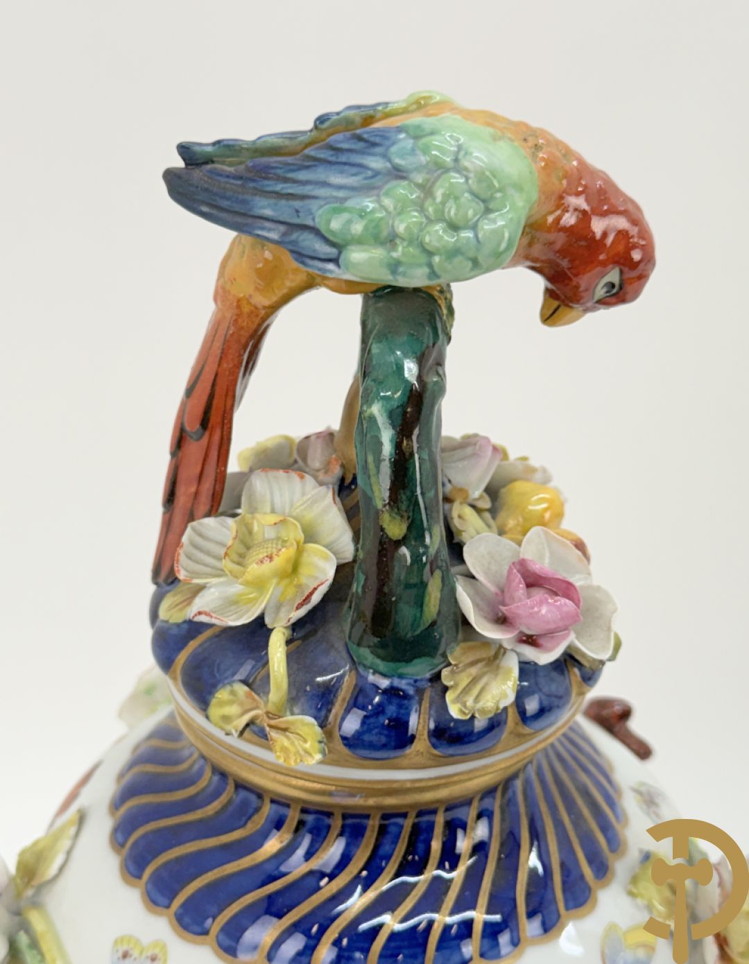 Porseleinen siervaas met handbeschilderd geanimeerd decor bezet met basrelief van bloemen en bovenaan bekroond met deksel met vogel