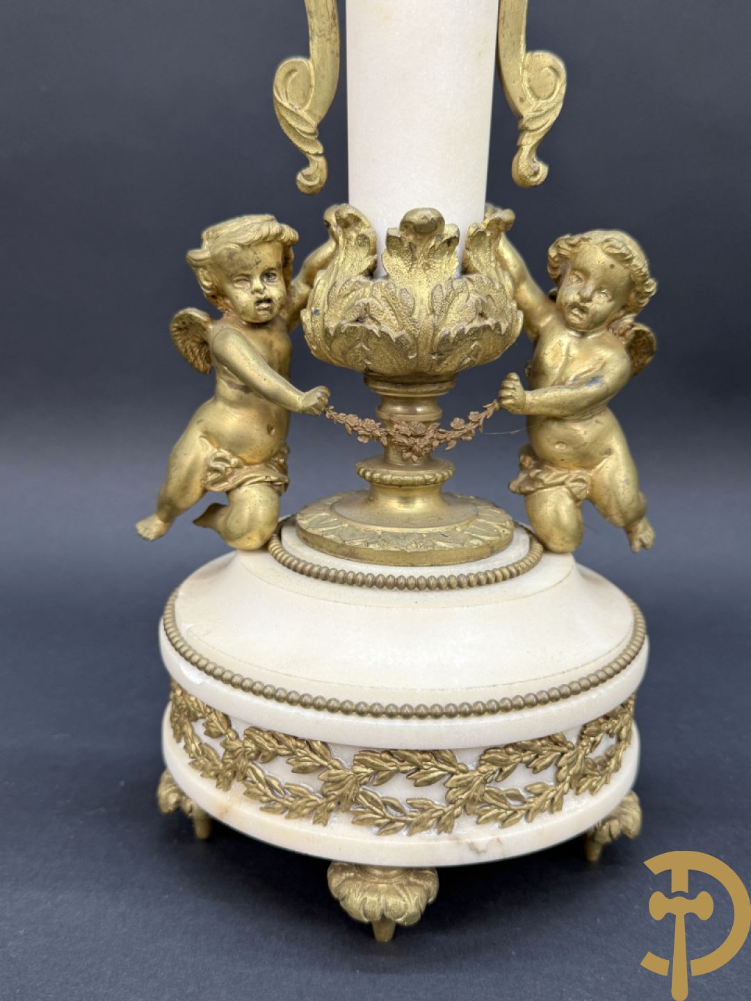 Paar marmeren kandelaars met bronzen cupido