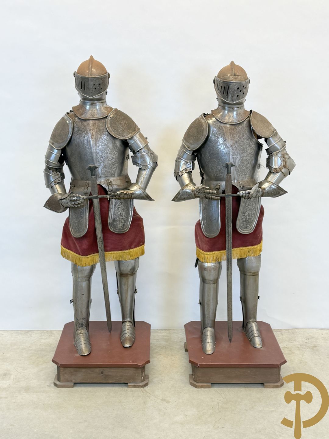 Paar ijzeren decoratieve harnassen ridderuitrusting met geciseleerde motieven op de elementen, met zwaard en ridderhelm - op statief - vermoedelijk Spaans 1930-1940